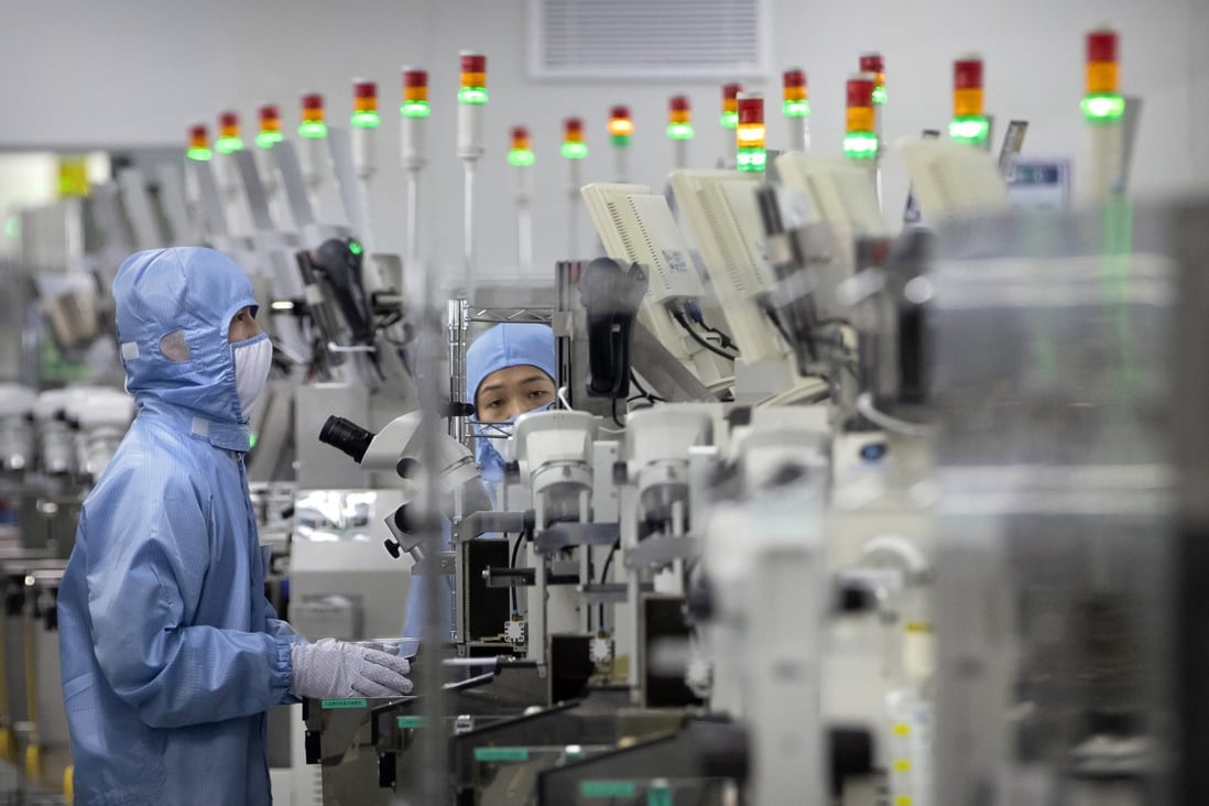 Employees wearing protective equipment work at a semiconductor production facility in China. Photo: AP 