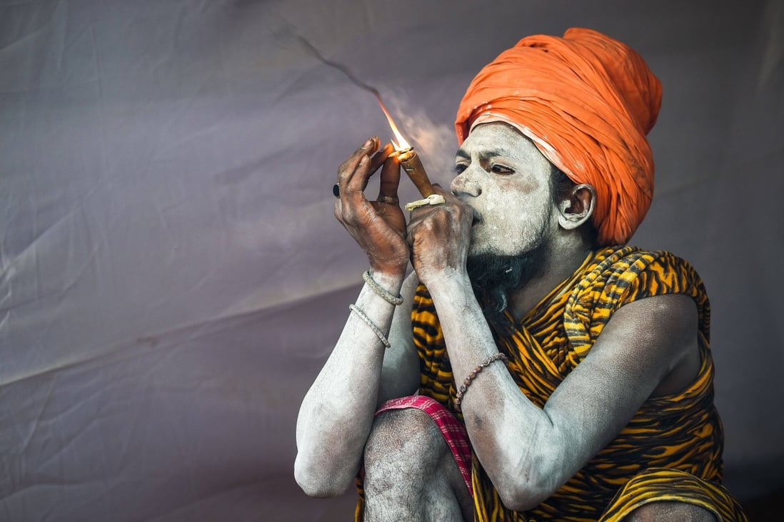 An Indian sadhu smokes inside his tent at the Kumbh Mela festival in Allahabad. Photo: AFP