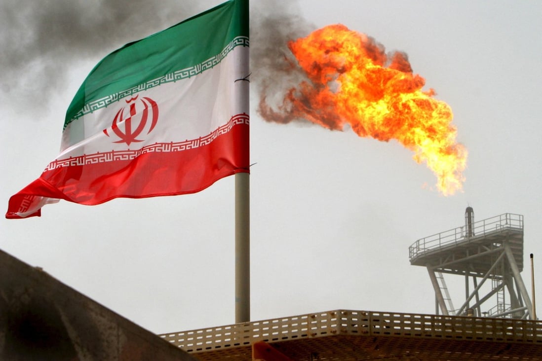 A gas flare on an oil production platform in the Soroush oil fields alongside an Iranian flag in the Gulf. Photo: Reuters
