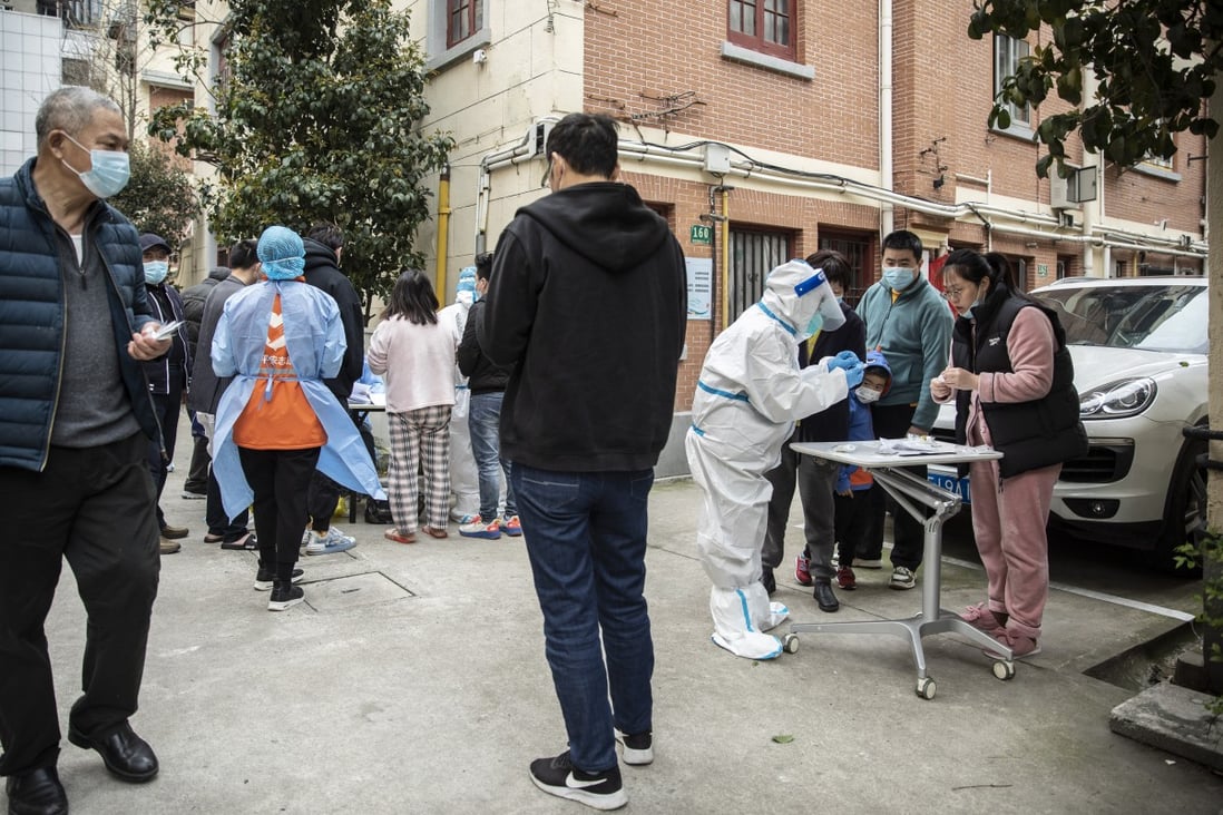 Residents gather to receive rapid antigen test kits for Covid-19 at a neighbourhood in Shanghai on Saturday. Photo: Bloomberg
