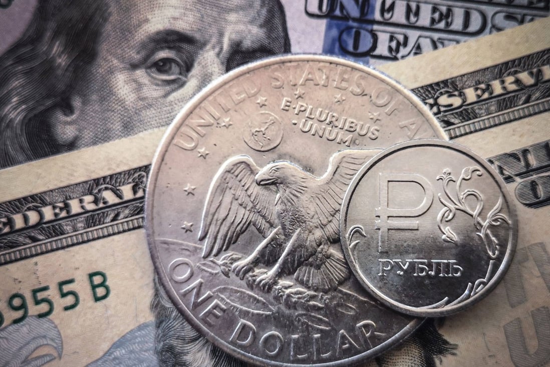 A Russian rouble coin is pictured with US dollar bills and a US$1 coin in Moscow, on March 15. The dollar benefits not just the US but also its users, who create an ecosystem that entrenches its superiority. Photo: AFP