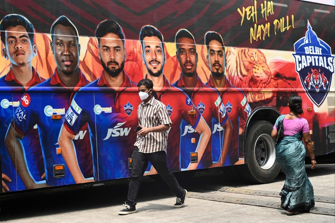 Pedestrians walk past the bus of Indian Premier League’s (IPL) Delhi Capitals in Mumbai. Photo: AFP
