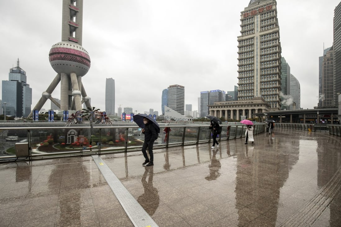 Pedestrians pass buildings in Pudong’s Lujiazui dinancial district in Shanghai in February 2022. Photo: Bloomberg