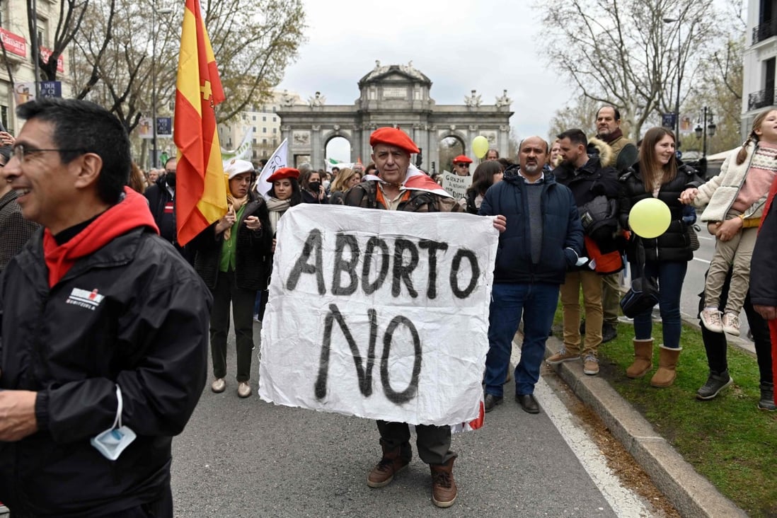 A protester wearing a Carlist red beret holds a banner during a demonstration protesting against abortion in Madrid, Spain on March 27. Photo: AFP