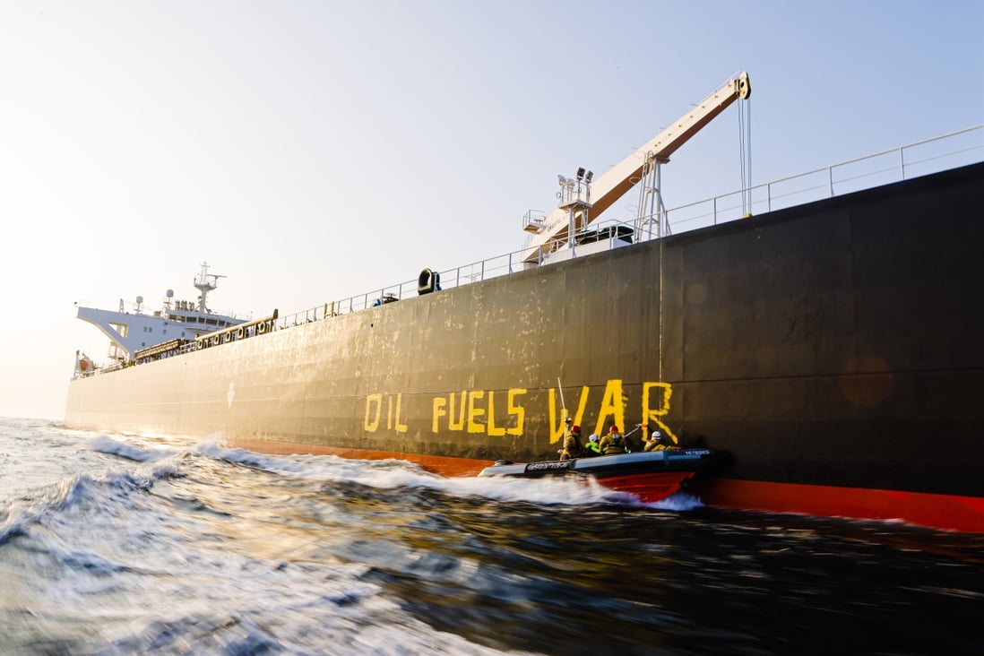 Activists from environmental organisation Greenpeace paint the words “Oil fuels war” on the hull of a ship carrying Russian oil in the Baltic Sea. Photo: Frank Molter/dpa