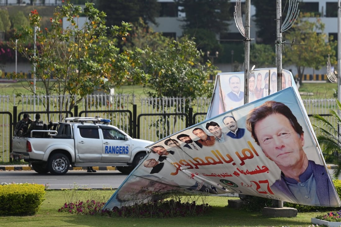 A fallen hoarding bearing the image of PM Imran Khan is seen in front of Parliament House in Islamabad. Photo: AFP