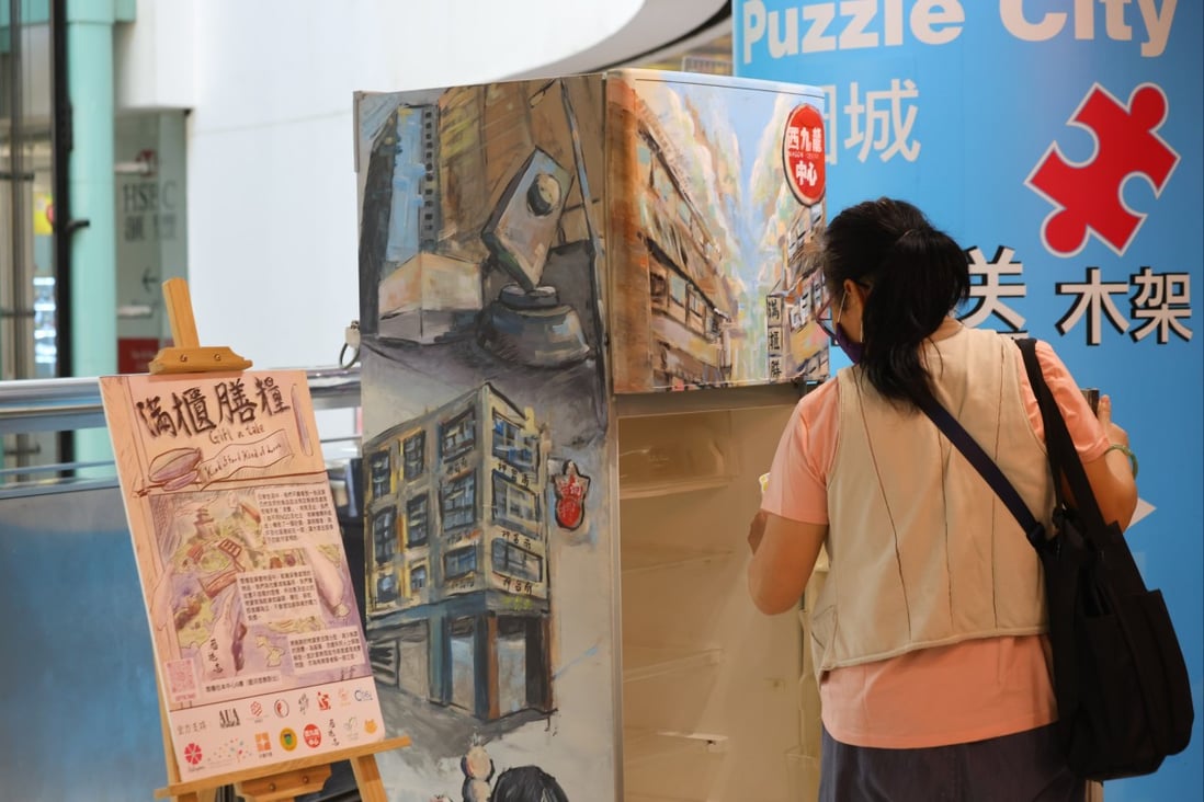 A woman takes free food from a refrigerator at Dragon Centre in Sham Shui Po on March 18. More people have needed food assistance and other forms of help since the pandemic began. Photo: Dickson Lee