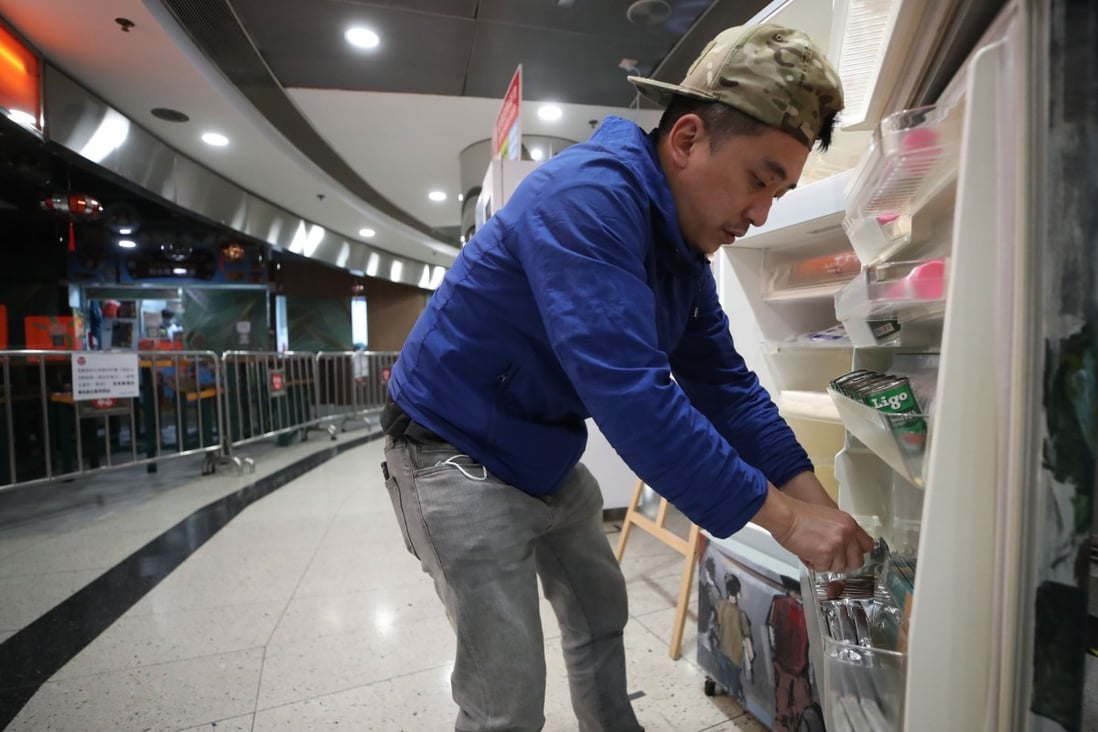 Wong Wai-kit, founder of the “Gift n Take” fridge project, replenishes food at the Dragon Centre in Sham Shui Po on March 24. He has filled about 40 fridges across Hong Kong to feed the underprivileged so they don’t have to scavenge for leftovers. Photo: Edmond So