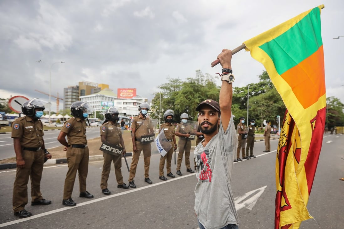A man holds a Sri Lankan national flag during a protest, calling for the resignation of president over the alleged failure to address the economic crisis, outside the Parliament complex in Colombo, Sri Lanka on Thursday. Photo: EPA-EFE