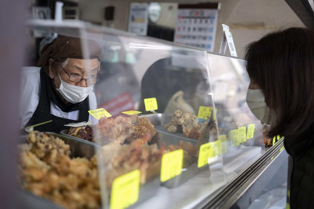 An elderly woman sells tempura at a restaurant in Tokyo’s Sunamachi area on March 9. Prices are rising in Japan, but unlike inflation seen in many other places, the increases are long-sought but also unlikely to last, analysts say. Photo: AFP