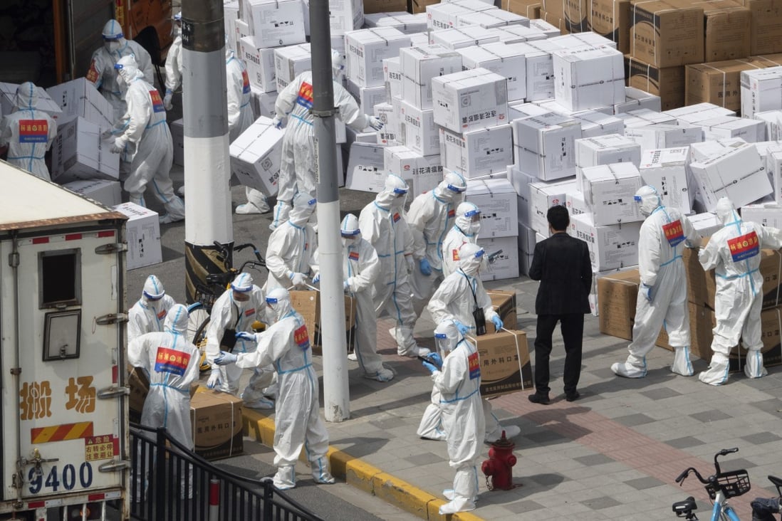 Workers unload supplies including boxes of masks in Shanghai on April 10, 2022. Photo: Chinatopix via AP