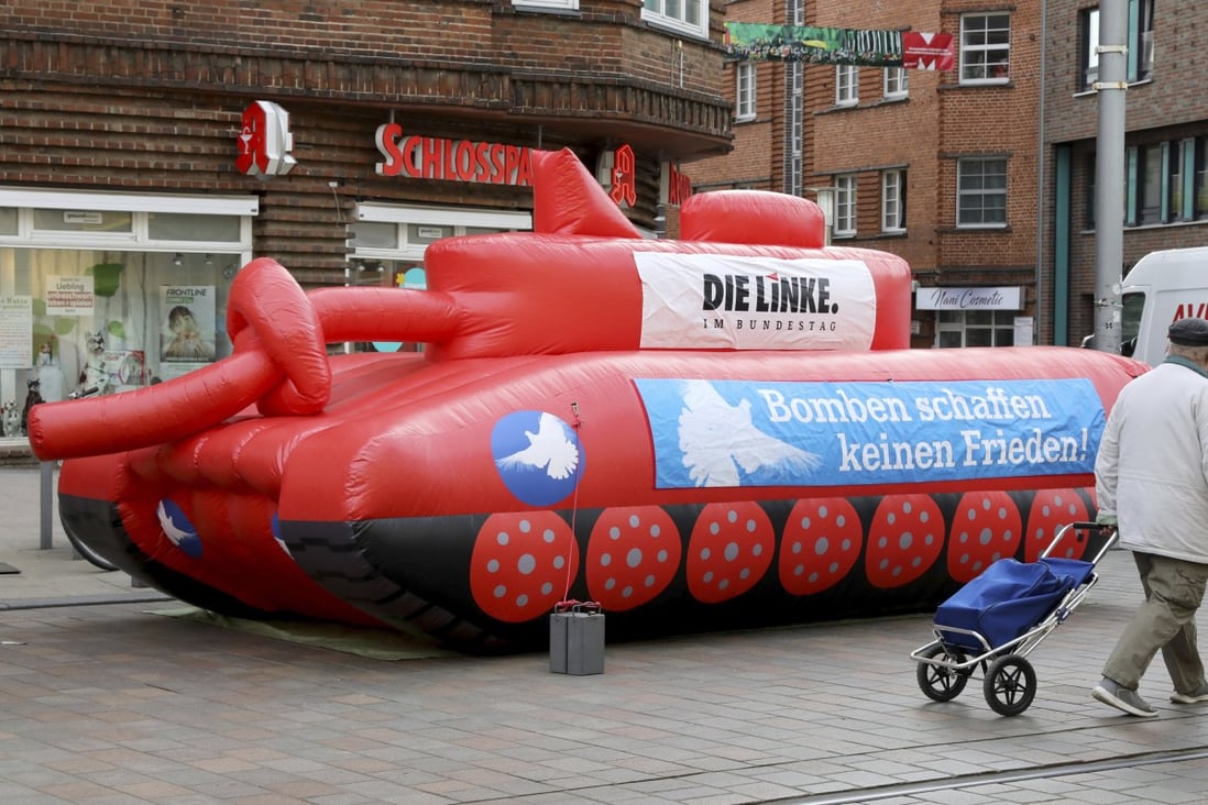 An inflatable tank with a knotted gun barrel stands at Marienplatz in Schwerin, Germany, on April 12. A banner on the tank reads “Bombs don’t create peace”. Photo: AP
