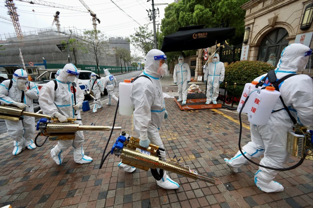 Volunteers in protective suits prepared to disinfect a residential compound in Huangpu district, to curb the spread of the coronavirus disease (COVID-19), in Shanghai on April 14, 2022. Photo: China Daily via Reuters.