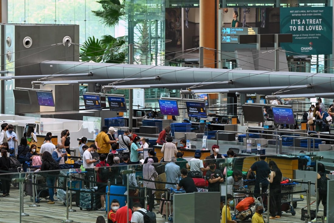 Travellers queue for self check-in before departure at Changi International Airport in Singapore on April 1, 2022. Singapore has reopened its land and air borders to travellers fully vaccinated against the Covid-19 coronavirus. Photo: AFP
