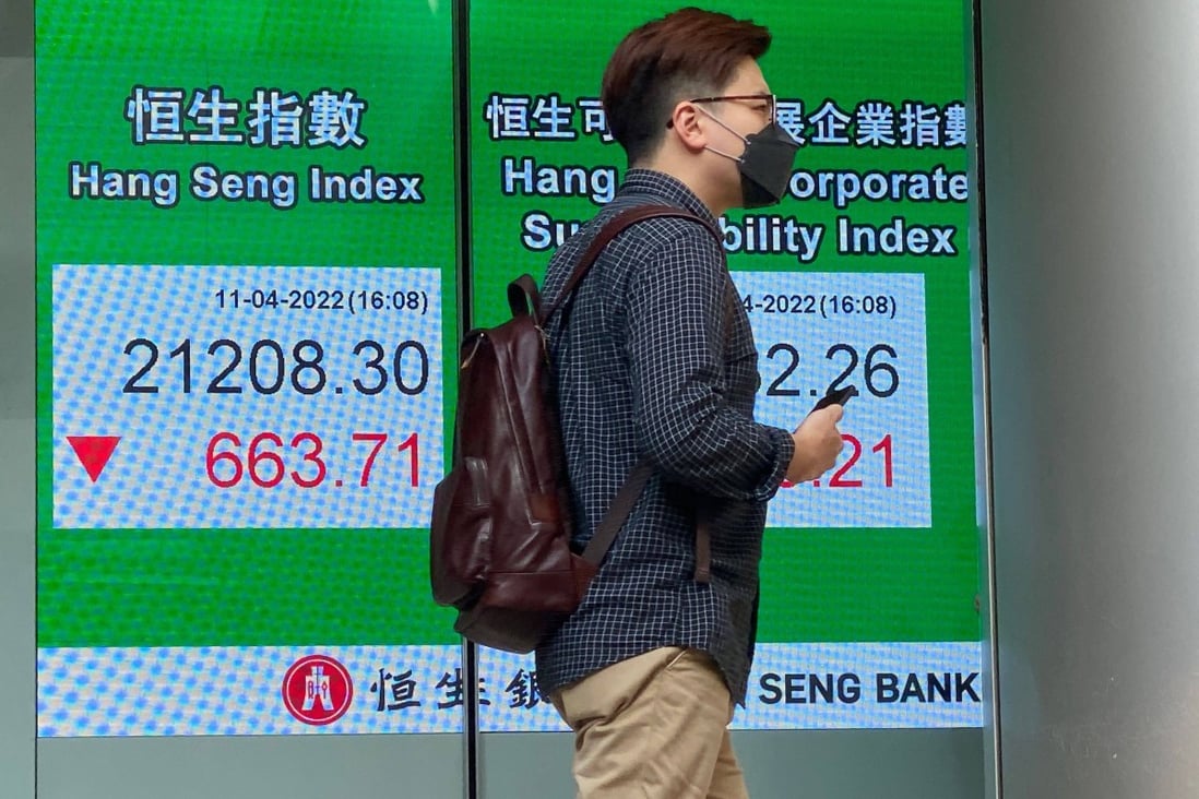 A man walks past a sign showing the Hang Seng Index ion April 11. Photo: AFP