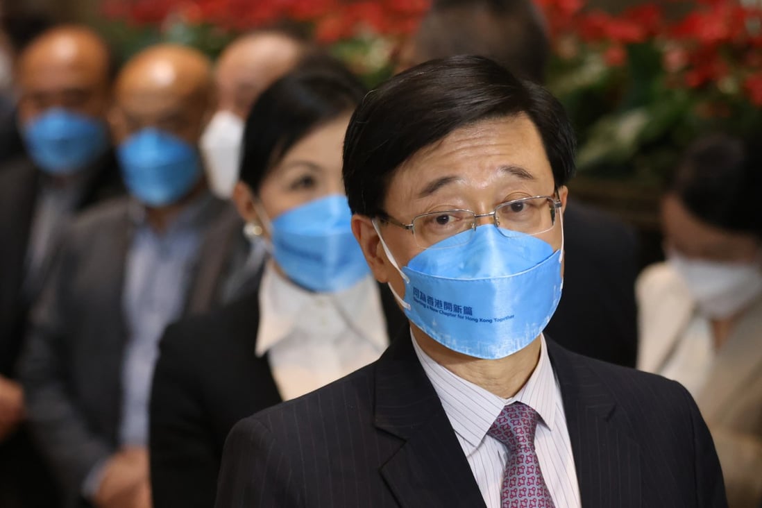 Chief executive hopeful John Lee Ka-chiu, wearing a mask bearing his campaign slogan “Starting a New Chapter for Hong Kong Together”, meets the media at Central Plaza in Wan Chai on April 18. Photo: Nora Tam