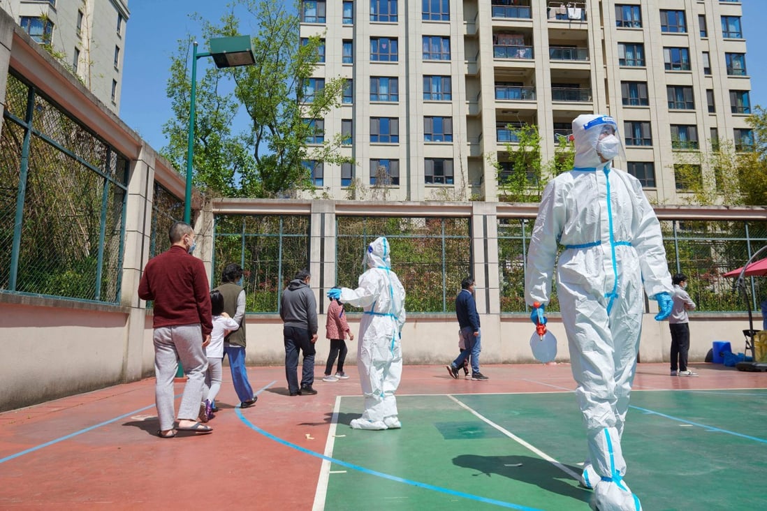 Community volunteers wearing personal protective equipment organise residents for a Covid-19 test in a compound during a lockdown in Pudong district in Shanghai on April 17, 2022. Photo: AFP