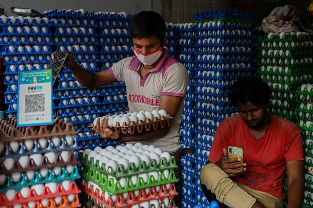 Men work at a poultry shop with a QR code displayed for Paytm, an Indian cellphone-based digital payment platform, in Mumbai. Photo: AFP