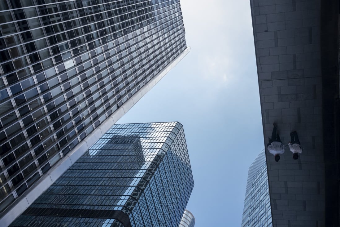 People are reflected in an awning next to office buildings during lunch hour in the Central district of Hong Kong, China, on Monday, June, 7, 2021. Photo: Bloomberg