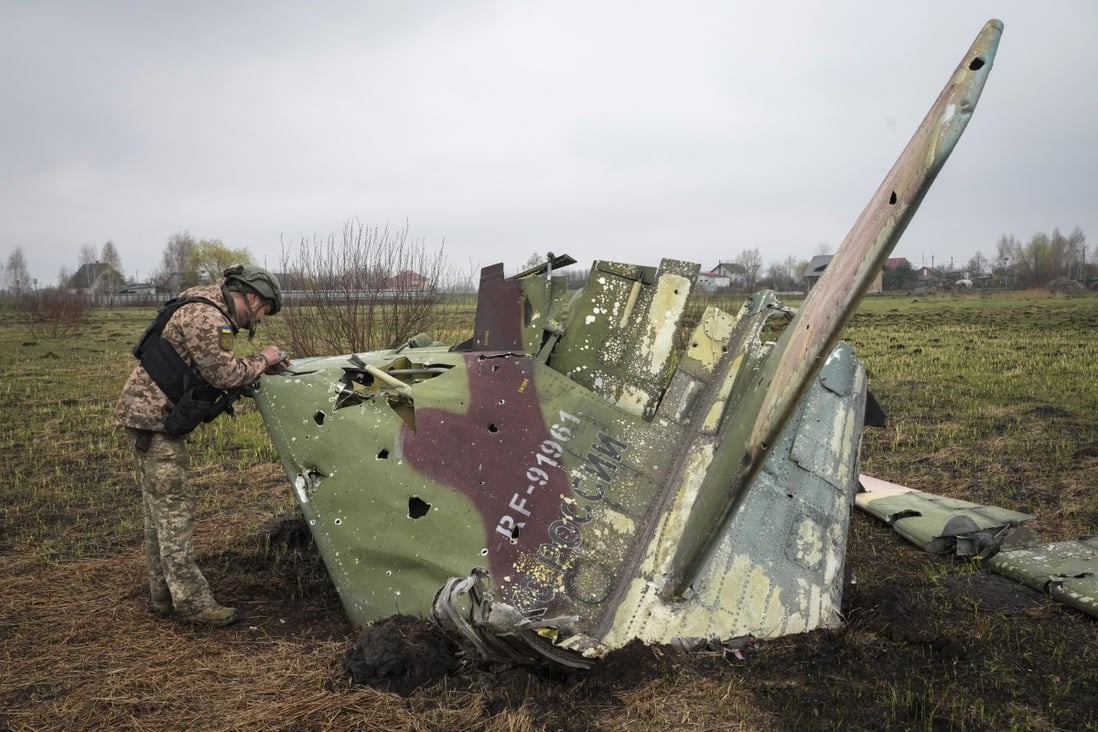 A Ukrainian soldier examines a fragment of a Russian Air Force Su-25 jet after a recent battle at the village of Kolonshchyna. Photo: AP