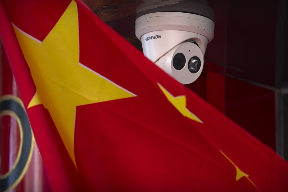A Chinese flag hangs near a Hikvision security camera outside of a shop in Beijing. Photo: AP