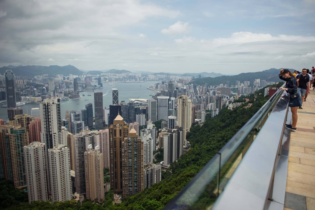 Tourists stand on the viewing platform of Victoria Peak in front of the Hong Kong skylineon August 19, 2019. Photo: Getty Images