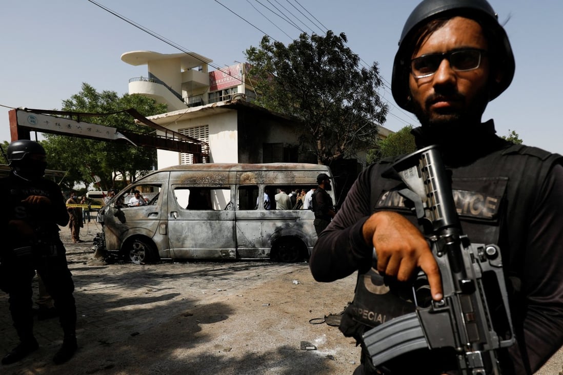 A police officer stands guard near the van’s remains, after the explosion which killed four people outside the University of Karachi’s Confucius Institute. Photo: Reuters