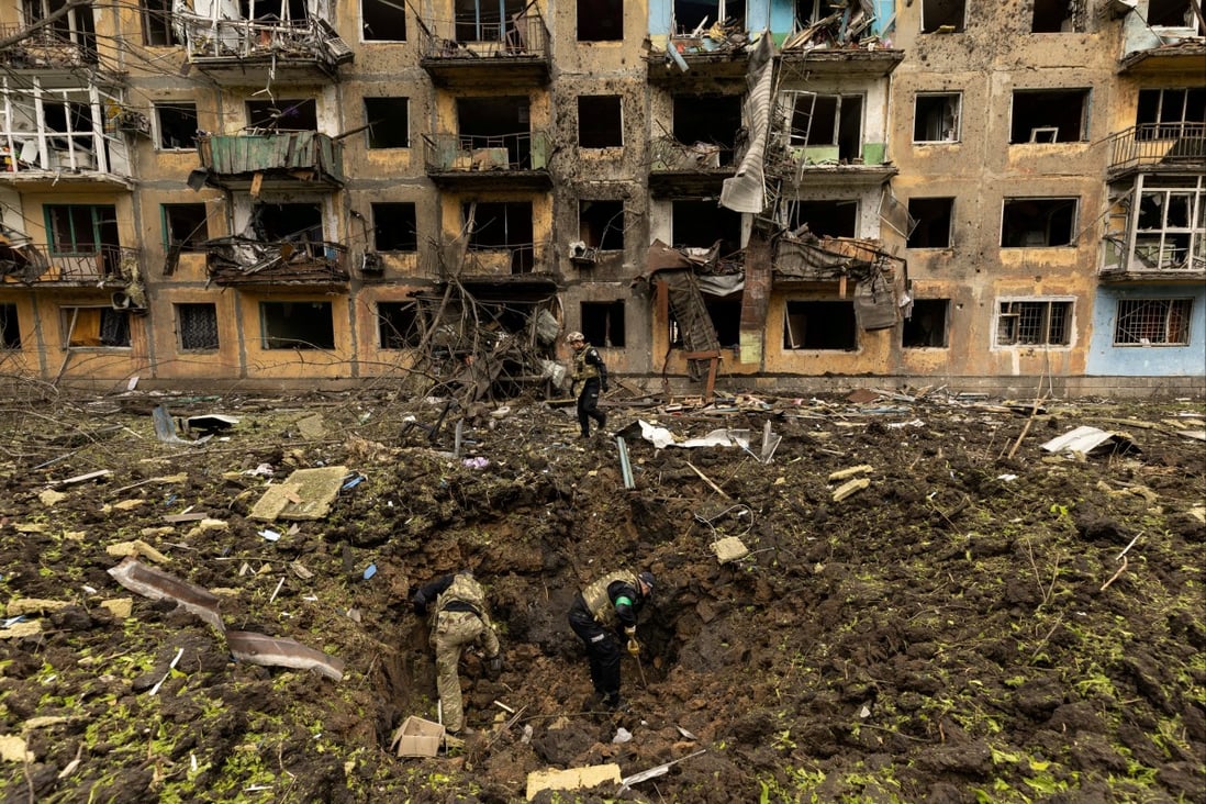 Ukrainian military personnel inspect the site of a missile strike in front of a damaged residential building in Dobropillia, in the Donetsk region, Ukraine, on Saturday. Photo: Reuters