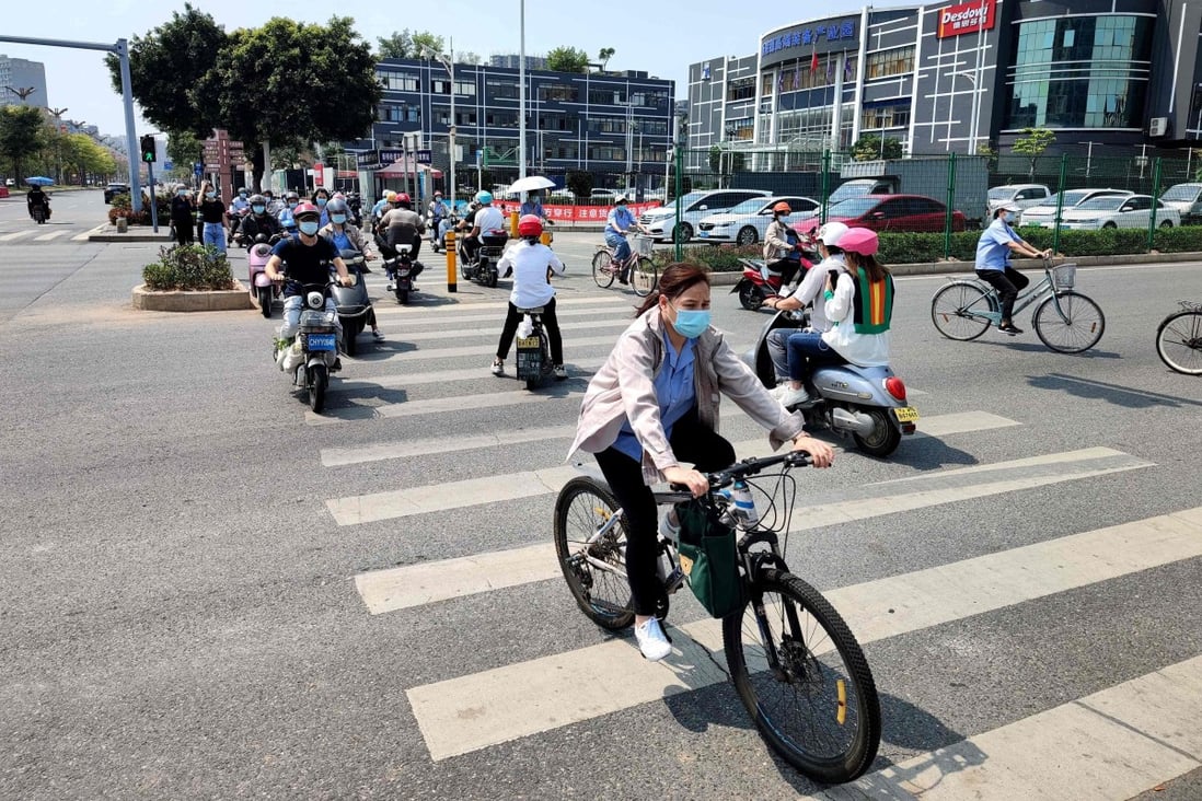 Shenzhen residents ride scooters and bicycles along a street on March 21, after the city was reopened following a week-long lockdown to combat a Covid-19 outbreak. Photo: AFP