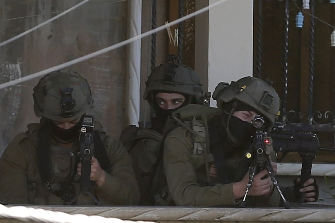 Israeli security forces take positions as they search houses in the West Bank village of Romana near Jenin city. Photo: EPA