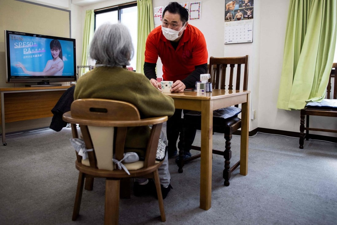 Retired Japanese sumo wrestler Hiromi Yamada, who competed under the name Wakatoba, takes care of an elderly woman at the Hanasaki daycare centre in Tokyo on April 6. Countries around the Asia-Pacific are in dire need of care staff, leading them to think outside the box in addition to importing labour from overseas. Photo: AFP