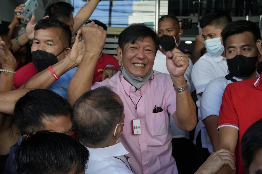Ferdinand “Bongbong” Marcos Jnr celebrates as he greets the crowd outside his headquarters in Mandaluyong, Manila on Wednesday. Photo: AP