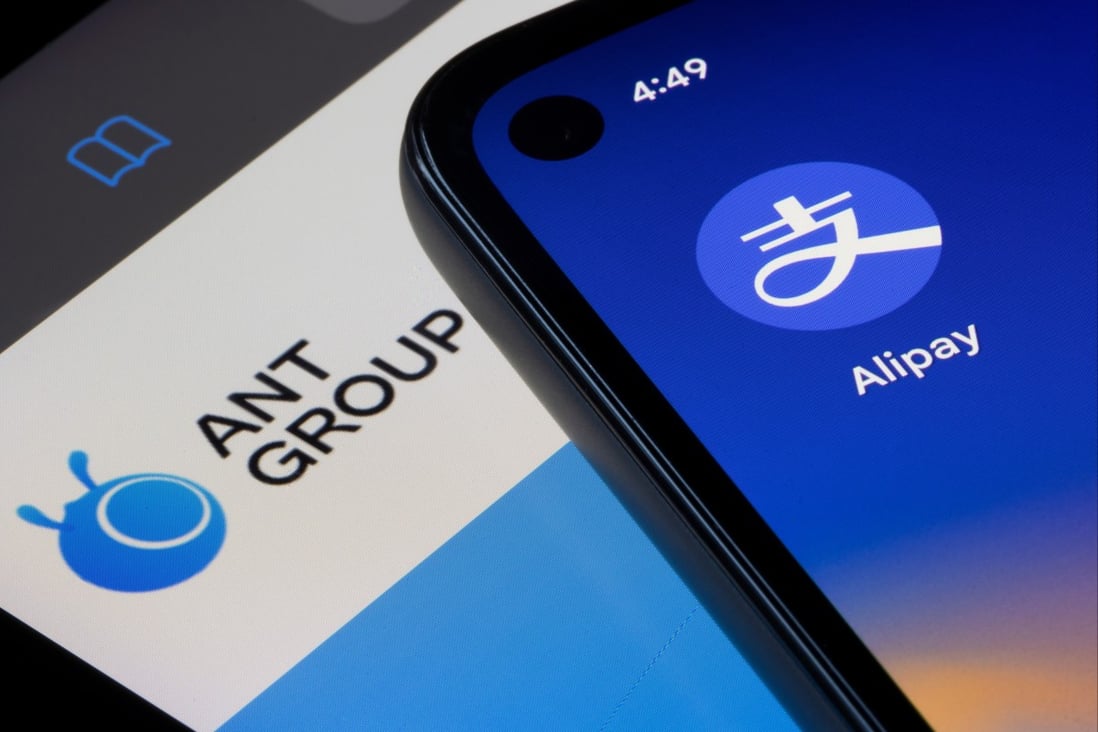 The Alipay app icon is seen on a smartphone on top of an iPad screen showing the homepage of Ant Group. Photo: Shutterstock