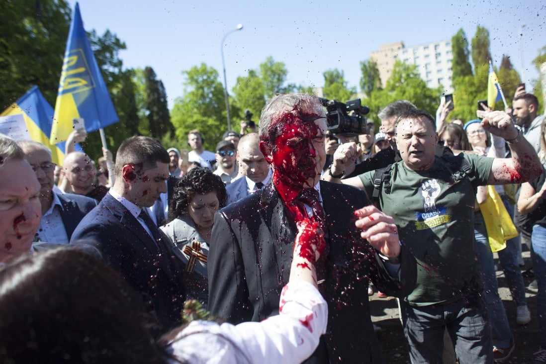 Protesters in Poland throw red paint at Russian ambassador Sergey Andreev as he arrives at a cemetery in Warsaw on May 9 to pay respects to Red Army soldiers who died during World War II. Photo: AP