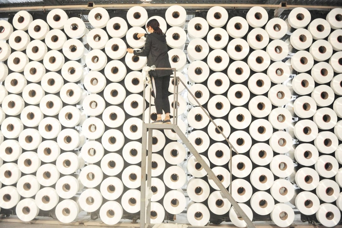 An employee adjusts spools of thread at a textile factory in Hangzhou in China’s Zhejiang province on April 17. Photo: AFP