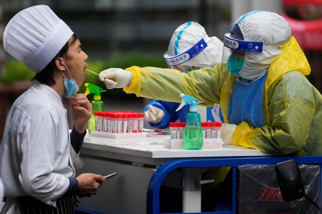 A medical worker in a protective suit collects a swab sample from a chef for nucleic acid testing, during lockdown, amid the coronavirus disease (COVID-19) pandemic, in Shanghai on May 13, 2022. Photo: Reuters