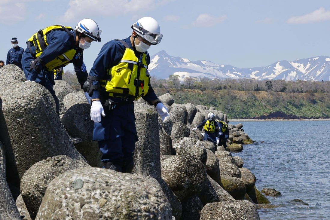 Police officers search coastal areas in Shibetsu, Hokkaido on Monday for clues on people who went missing after a tourist boat sank off the Shiretoko Peninsula of the northernmost Japanese main island on April 23. Photo: Kyodo