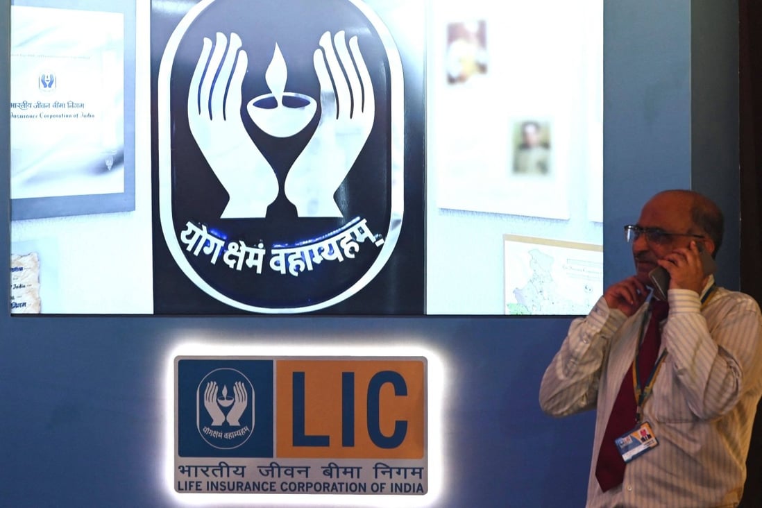 A man speaks on his mobile phone standing next to a Life Insurance Corporation of India (LIC) sign ahead of the company’s listing ceremony at the Bombay Stock Exchange (BSE) in Mumbai on Tuesday. Photo: AFP