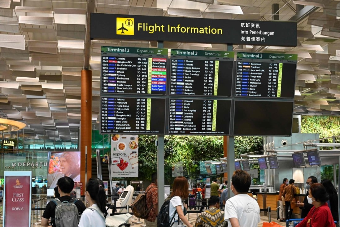Travellers look at information regarding their flights in the departure hall at Changi International Airport in Singapore. Photo: AFP