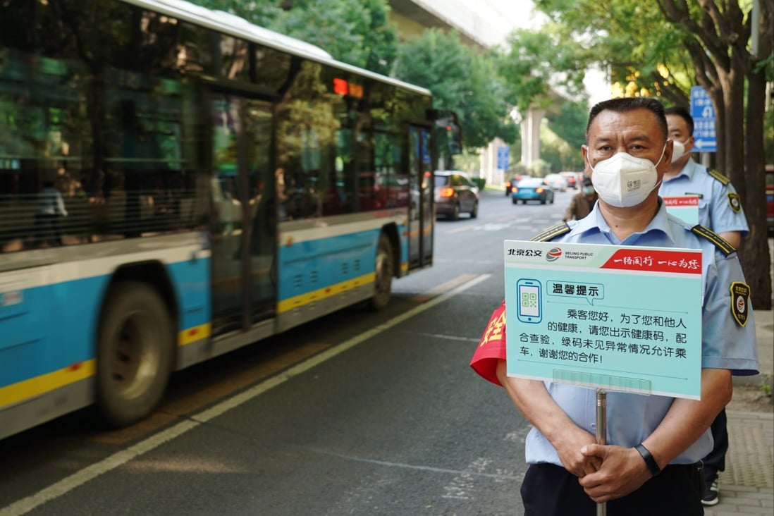 Staff members of Beijing Public Transport hold signboards to remind passengers to show health QR codes at a bus stop in Beijing on May 17, 2022.
Photo: Xinhua