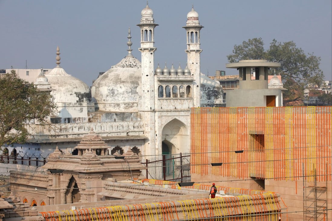A worker stands on a temple rooftop adjacent to the Gyanvapi Mosque in the northern city of Varanasi, India/ Photo: Reuters