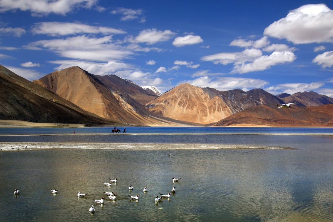 An Indian tourist rides on a horse at Pangong lake high up in Ladahak region of India. Photo: AP
