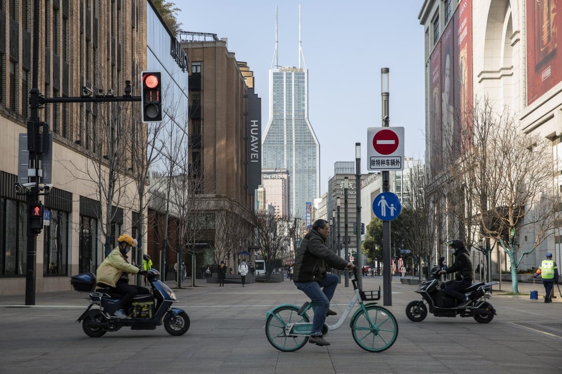 Cyclists and motorcyclists ride along Nanjing Road in Shanghai on February 27. Photo: Bloomberg