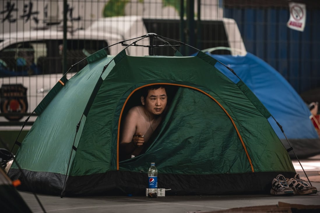 A delivery worker sits under the bridge in his tent, amid the ongoing Covid-19 lockdown in Shanghai, on 23 May 2022. Photo: EPA-EFE