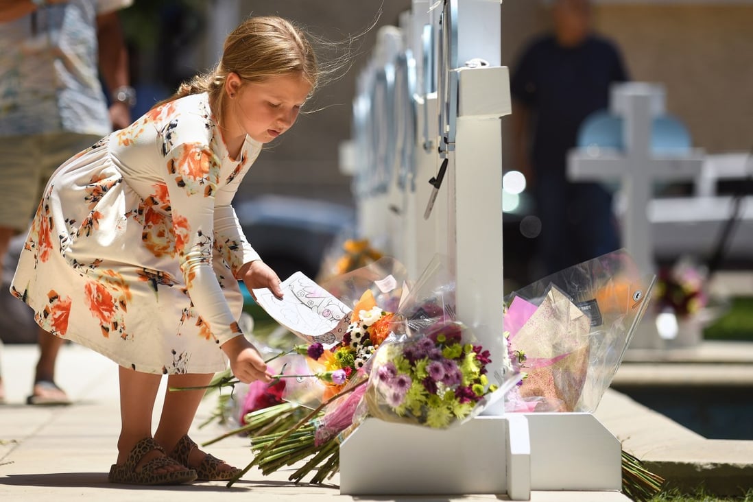 A little girl laces flowers at a memorial for the victims of the mass shooting in Uvalde, Texas. Photo: TNS