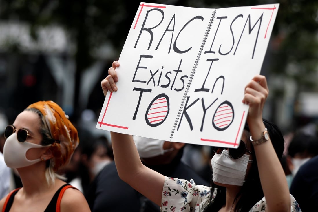 A demonstrator holds a placard during a protest march in Japan in 2020. Photo: Reuters