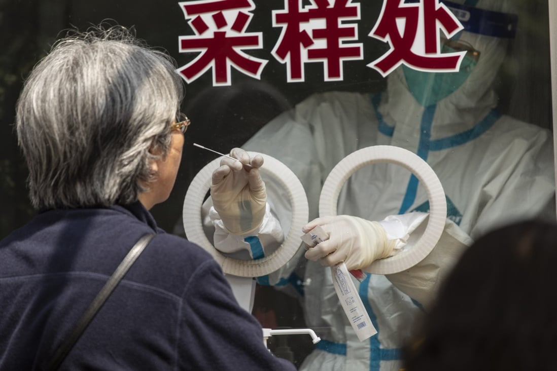A healthcare worker in personal protective equipment (PPE) takes a swab sample at a Covid-19 testing centre in Shanghai, May 27, 2022. Photo: Bloomberg