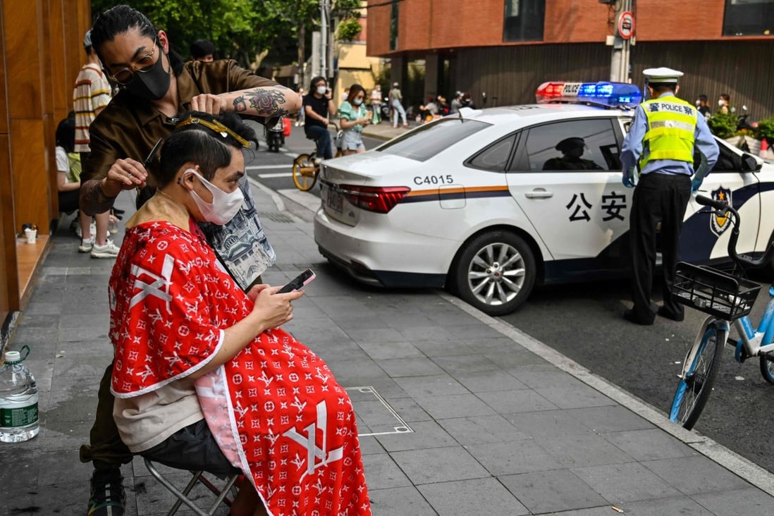 A man having a haircut on a street during a lockdown in Shanghai on May 27 as restrictions are gradually eased. Photo: AFP