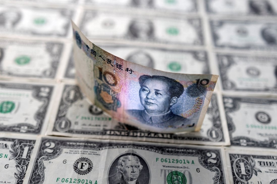 A 10 yuan banknote is displayed on top of US dollar bills in this illustration taken on February 14. Markets instinctively recognise that the yuan still faces major headwinds. Photo: Reuters
