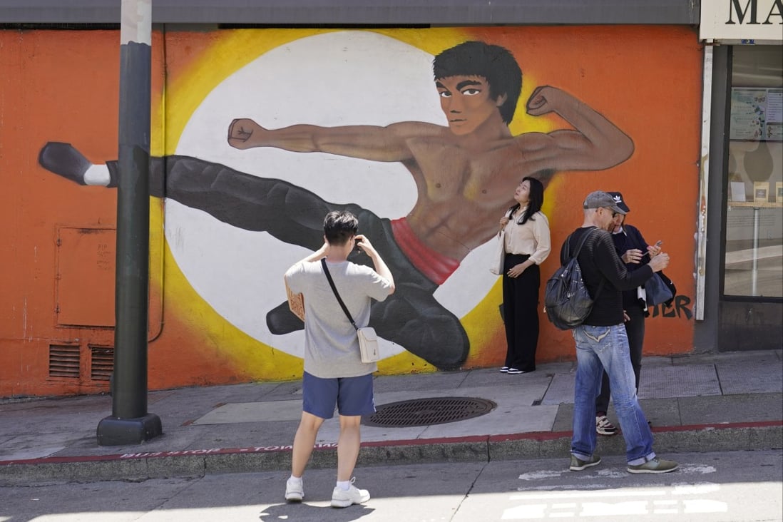 People stop to take pictures by a Chinatown mural of martial artist Bruce Lee in San Francisco. Photo: AP